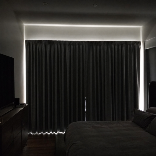 A bedroom in daytime made almost completely dark by NOVIQ Dark blackout curtains, with daylight showing only as a rim around the edges