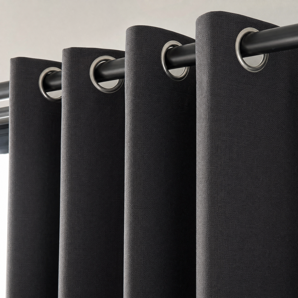 Close-up of the metal grommet eyelets on a NOVIQ Dark curtain panel threaded onto a black pole